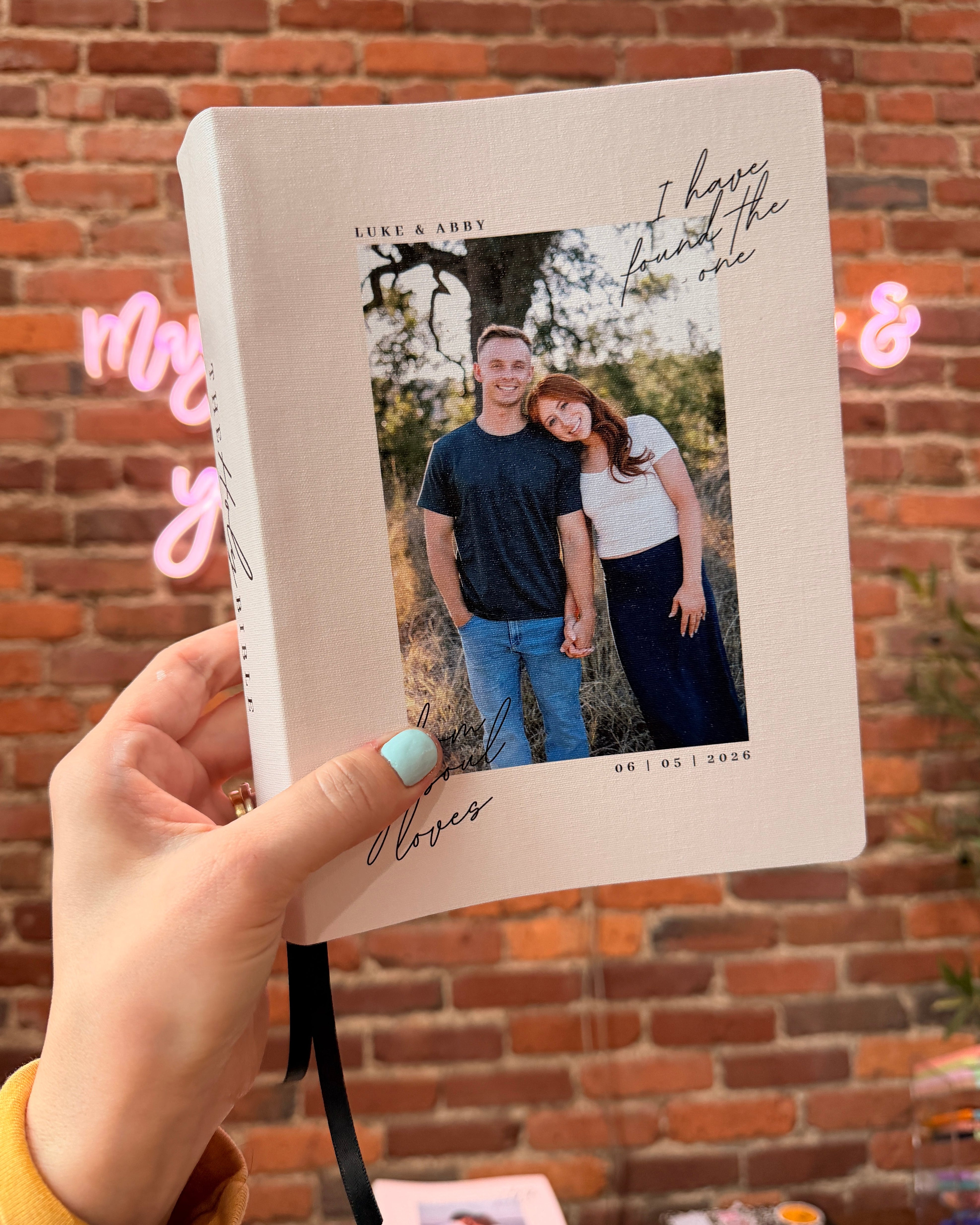 Personalized Lorenz Wedding Bible held in front of a brick wall
